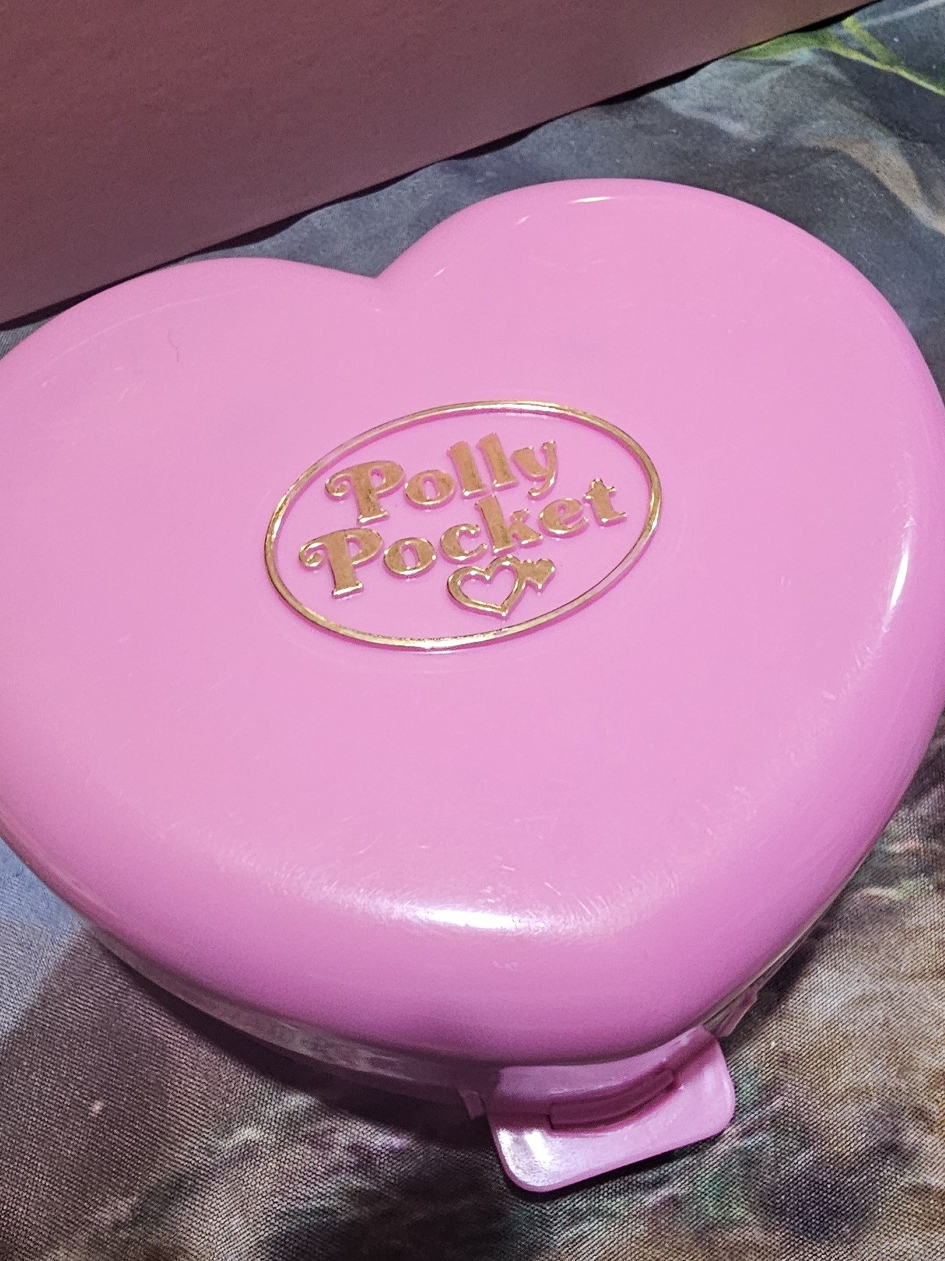 Pink heart-shaped Polly Pocket compact with the Polly Pocket name moulded into an oval on the lid, from the Bluebird era